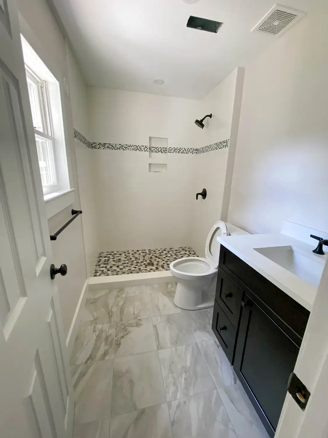 Compact marble bathroom, bathroom remodeling project in Northern Virginia by HOM Design & Build, view 1