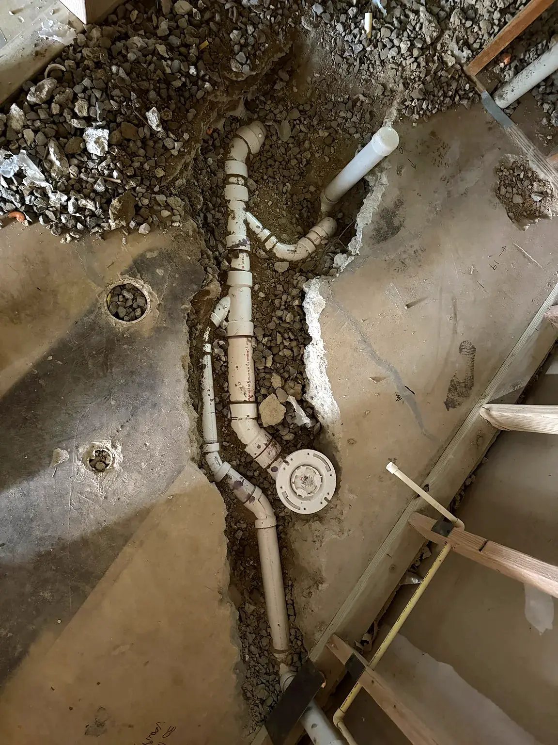 Under-slab drain piping exposed during basement bathroom construction in Prince William Commons, Woodbridge, Virginia