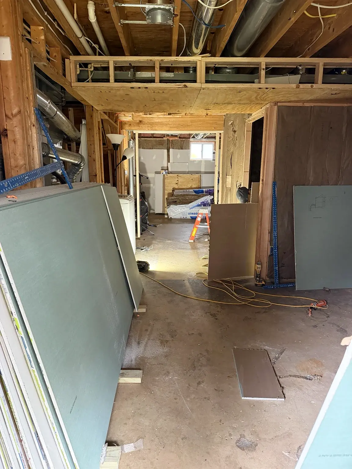 Wallboard staged beside framed basement rooms in Prince William Commons, Woodbridge, Virginia