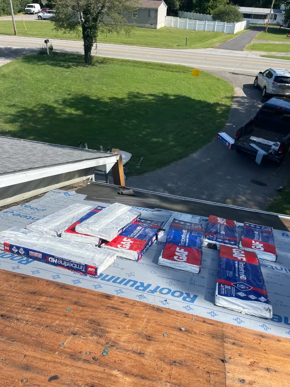 GAF Timberline HD shingle bundles staged on RoofRunner synthetic underlayment beside exposed decking